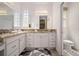 Bathroom featuring double sinks, granite counters, vanity, toilet room, and decorative mirror at 3432 Wise Way, The Villages, FL 32163
