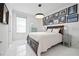 Bright bedroom with a decorative light fixture, neutral walls, and framed artwork above the bed at 3432 Wise Way, The Villages, FL 32163