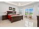 Bright bedroom featuring tray ceilings, a chandelier, and large windows offering beautiful outdoor views at 3432 Wise Way, The Villages, FL 32163