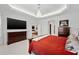 Well-lit bedroom featuring tray ceilings, a modern chandelier, with easy access to other rooms in the house at 3432 Wise Way, The Villages, FL 32163