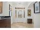 Inviting foyer with decorative lighting, elegant tile flooring, and a stylish front door at 3432 Wise Way, The Villages, FL 32163