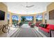 Enclosed patio with stylish seating, ceiling fans, and views of the pool and lush backyard at 3432 Wise Way, The Villages, FL 32163