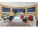 Beautiful enclosed patio with comfortable seating, ceiling fans, and views of the pool and golf course at 3432 Wise Way, The Villages, FL 32163