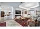 Bright living room featuring a fireplace, large screen TV, chandelier, and elegant decor at 3432 Wise Way, The Villages, FL 32163
