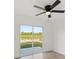 This bedroom features wood flooring, a ceiling fan, and sliding glass doors with backyard views at 3813 Long Grove Ln, Port Orange, FL 32129