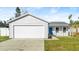 Charming single-story home with a blue front door, a garage, and a well-maintained lawn at 3813 Long Grove Ln, Port Orange, FL 32129