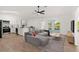 Bright open-concept living area with modern kitchen, wood floors and sliding doors to the outside at 3813 Long Grove Ln, Port Orange, FL 32129