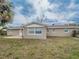 View of the backyard showing the exterior of the house, lawn, and trees at 412 Cherry St, South Daytona, FL 32119