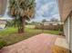 The backyard features a brick patio, a large palm tree, a fence, and a grassy area at 412 Cherry St, South Daytona, FL 32119