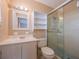 Bright bathroom featuring a glass-enclosed shower, white vanity and shelving at 412 Cherry St, South Daytona, FL 32119