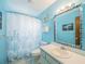 Coastal-themed bathroom featuring a decorated mirror, shower curtain and blue walls at 412 Cherry St, South Daytona, FL 32119