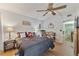Bedroom with a ceiling fan, bedside tables, wood floors, and a glimpse of the staircase at 4150 S Atlantic Ave # 104 B, New Smyrna Beach, FL 32169