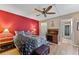 Bedroom featuring a red accent wall, wood floors, comfortable bed, and an adjacent desk area at 4150 S Atlantic Ave # 104 B, New Smyrna Beach, FL 32169