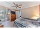Comfortable bedroom with access to a private balcony, hardwood floors, and a ceiling fan at 4150 S Atlantic Ave # 104 B, New Smyrna Beach, FL 32169
