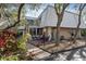 Inviting home exterior with a small front porch with chairs and a balcony overhead, complemented by lush landscaping at 4150 S Atlantic Ave # 104 B, New Smyrna Beach, FL 32169