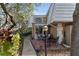 Inviting home exterior with a small front porch with chairs and a balcony overhead, complemented by lush landscaping at 4150 S Atlantic Ave # 104 B, New Smyrna Beach, FL 32169