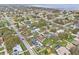Expansive aerial view showcases a neighborhood with mature trees, glimpses of a lake, and lush greenery at 445 Virginia Ave, St Cloud, FL 34769
