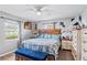 Comfortable bedroom with a plaid bedspread, matching blue bench, and lots of bright natural light at 445 Virginia Ave, St Cloud, FL 34769