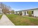 A cozy home featuring well-kept landscaping and energy-efficient solar panels on the roof at 445 Virginia Ave, St Cloud, FL 34769
