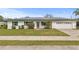 Charming single-story home with a well-manicured lawn, walkway, and solar panels at 445 Virginia Ave, St Cloud, FL 34769