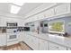Well-lit kitchen features white cabinetry, ample counter space, and natural light at 445 Virginia Ave, St Cloud, FL 34769