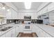 Well-lit kitchen featuring white cabinetry, stone countertops and modern appliances at 445 Virginia Ave, St Cloud, FL 34769