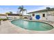 Inviting in-ground swimming pool surrounded by concrete decking, a lush lawn and mature landscaping at 445 Virginia Ave, St Cloud, FL 34769