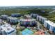 Aerial view showcasing the property within a lush, green setting, with tennis courts, ponds, and other buildings at 5300 S Atlantic Ave # 8-404, New Smyrna Beach, FL 32169