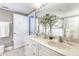 Spacious bathroom with double vanity, and decorative greenary reflected in a large mirror at 5300 S Atlantic Ave # 8-404, New Smyrna Beach, FL 32169