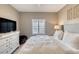 Neutral bedroom featuring a white dresser with black flatscreen TV and decorative fur basket for storage at 5300 S Atlantic Ave # 8-404, New Smyrna Beach, FL 32169