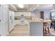 Open kitchen features white cabinets, stainless appliances, breakfast bar, and adjacent dining area at 5300 S Atlantic Ave # 8-404, New Smyrna Beach, FL 32169