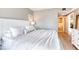 Bright main bedroom with white bedding and wood floors leading to an open bathroom and walk-in closet at 5300 S Atlantic Ave # 8-404, New Smyrna Beach, FL 32169