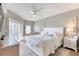 Bright bedroom featuring a plush bed, white furniture, and sunny view through shuttered glass doors at 5300 S Atlantic Ave # 8-404, New Smyrna Beach, FL 32169