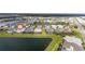 Aerial view of a neighborhood with houses surrounding a pond with lush landscaping at 583 Lost Shaker Way, Daytona Beach, FL 32124