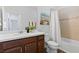 A bathroom with a shower-tub combo, white countertop vanity, and dark wood cabinets at 583 Lost Shaker Way, Daytona Beach, FL 32124