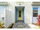 Charming front entry with a yellow door, light blue accents, brick path, and manicured landscaping at 583 Lost Shaker Way, Daytona Beach, FL 32124