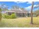 Exterior view of the home with a screened-in lanai and a spacious backyard at 5981 Jandon Ct, Port Orange, FL 32127