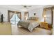 Bright bedroom features wood floors, a ceiling fan, and access to the screened patio at 5981 Jandon Ct, Port Orange, FL 32127