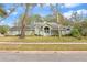 Charming single-story home featuring a well-manicured lawn, mature trees, and a welcoming front entrance at 5981 Jandon Ct, Port Orange, FL 32127