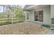 A stone-covered patio with a sliding door leading indoors and greenery outside at 5981 Jandon Ct, Port Orange, FL 32127
