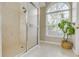 Bright bathroom featuring tiled walk-in shower and a large window providing natural light at 5981 Jandon Ct, Port Orange, FL 32127
