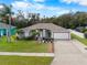 Inviting single-story home boasting a well-kept lawn, mature landscaping, and a traditional design with an attached two-car garage at 6058 Central Park Blvd, Port Orange, FL 32127