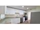 Modern kitchen with white cabinets, stainless steel appliances, and granite countertops at 685 E French Ave, Orange City, FL 32763