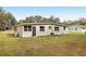 The house features a spacious, well-maintained backyard perfect for outdoor activities, complete with lush grass and mature trees at 722 Valencia Ave, Orange City, FL 32763