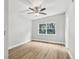 Cozy bedroom featuring wood look floors, a ceiling fan, and a window view at 722 Valencia Ave, Orange City, FL 32763