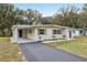 Street view of a recently renovated one-story home with a carport and fresh landscaping at 722 Valencia Ave, Orange City, FL 32763