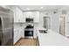 Modern kitchen featuring stainless steel appliances, white cabinets, and quartz countertops at 722 Valencia Ave, Orange City, FL 32763