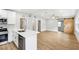 Open-concept living space with light wood floors and a modern barn door at 722 Valencia Ave, Orange City, FL 32763
