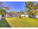 Spacious backyard with lush green lawn, mature trees, and partial fencing at 741 Greenway Pl, Daytona Beach, FL 32114