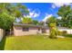 Back of house featuring a well-manicured backyard and lush trees at 741 Greenway Pl, Daytona Beach, FL 32114